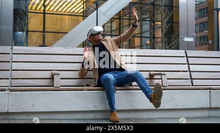 Business man using VR headset outdoors Stock Photo