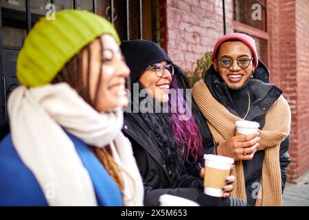 USA, New York City, Smiling friends enjoying cafe in city Stock Photo
