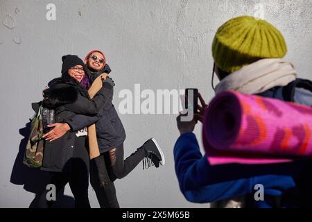USA, New York City, Woman photographing smiling friends with smart phone Stock Photo