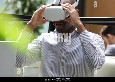 Businessman putting on virtual reality headset Stock Photo