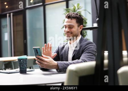 Smiling businessman having video call on phone Stock Photo