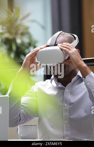 Businessman putting on virtual reality headset Stock Photo