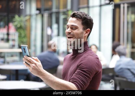 Young businessman having video call on phone Stock Photo