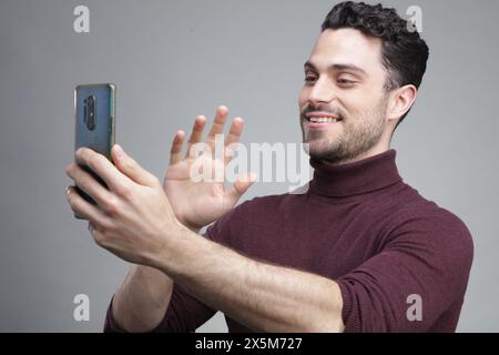Young man having video call on phone Stock Photo