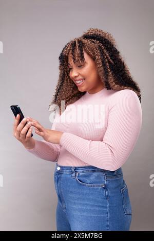 Smiling woman using smart phone Stock Photo