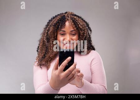 Smiling woman using smart phone Stock Photo