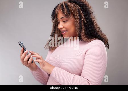 Smiling woman using smart phone Stock Photo