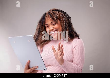 Smiling woman having video call on tablet Stock Photo