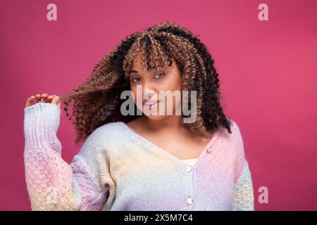 Portrait of smiling woman playing with hair Stock Photo