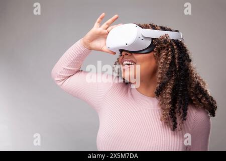 Smiling woman wearing virtual reality headset Stock Photo