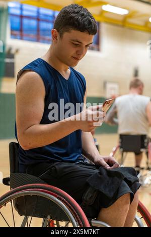 Male basketball player in wheelchair using smart phone Stock Photo