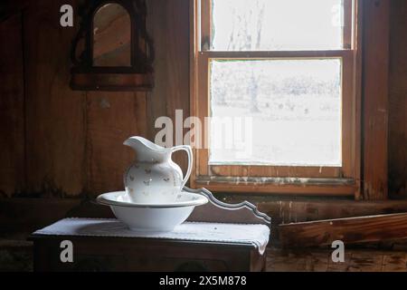 Fort Dodge, Iowa - A pitcher and washbasin in a bedroom at the Carlson-Richey Cabin at the Fort Museum and Frontier Village. Operated by the Fort Dodg Stock Photo