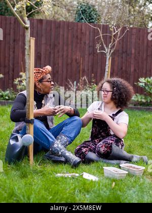 Mother and daughter talking in backyard Stock Photo