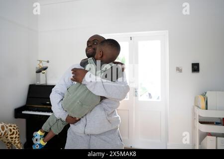 Man with Down syndrome holding boy (4-5) Stock Photo