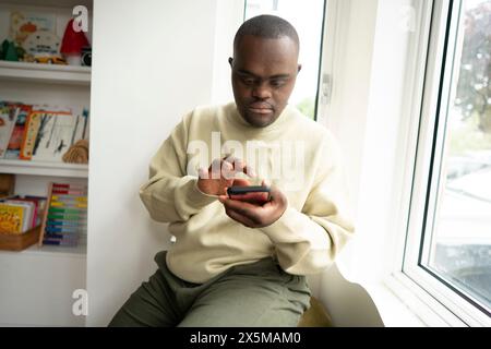 Man with Down syndrome using phone Stock Photo