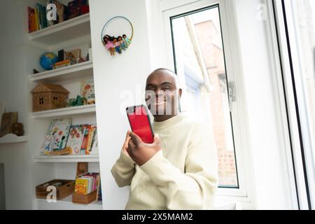 Man with Down syndrome using phone Stock Photo