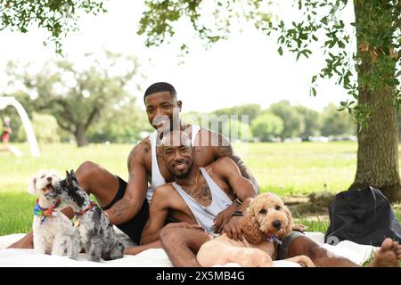 USA, Louisiana, Portrait of gay couple with dogs having picnic on lawn in park Stock Photo