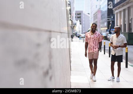 USA, Louisiana, Smiling gay couple walking in city Stock Photo