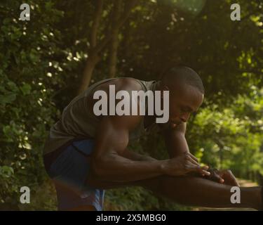 Athletic man stretching in park Stock Photo