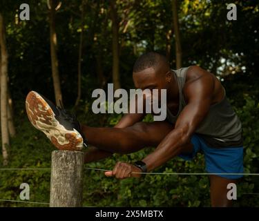 Athletic man stretching in park Stock Photo