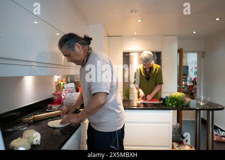 Senior couple cooking together in kitchen Stock Photo