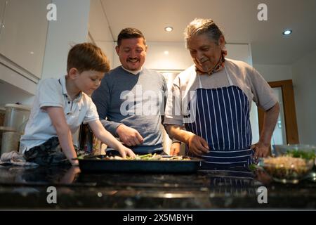 Senior man with son and grandson making pizza together Stock Photo