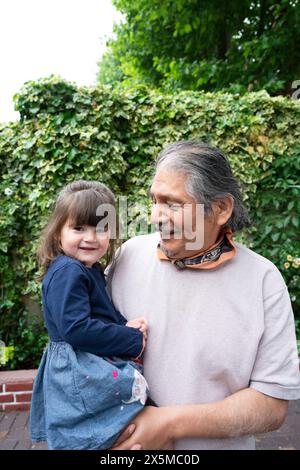 Smiling senior man with granddaughter outdoors Stock Photo