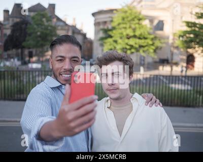 UK, South Yorkshire, Smiling gay couple taking selfie outdoors Stock Photo