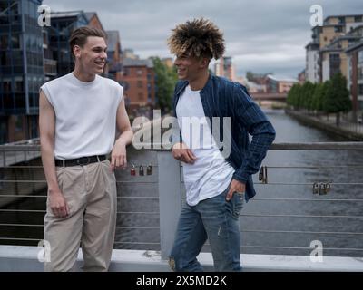 Young men standing on bridge and talking Stock Photo