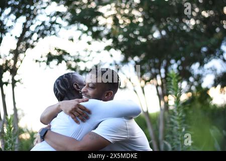 USA, Louisiana, Gay couple hugging in park Stock Photo