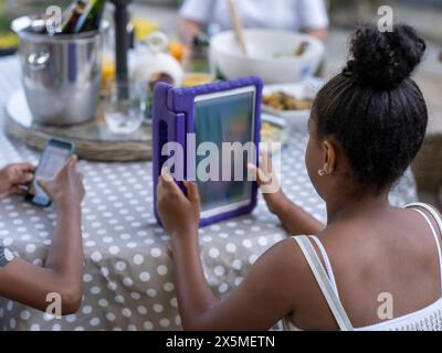 Siblings (8-9, 10-11) using digital tablet and smart phone Stock Photo