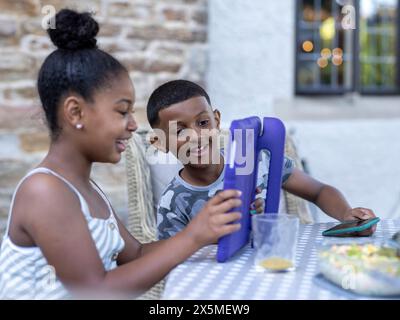 Siblings (8-9, 10-11) using digital tablet Stock Photo