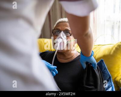 Nurse helping patient use oxygen mask Stock Photo