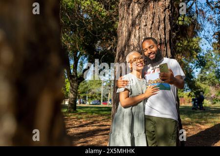 Couple taking selfie in park Stock Photo