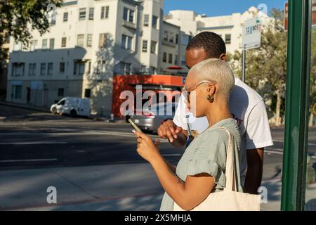Young couple using smart phone in city Stock Photo