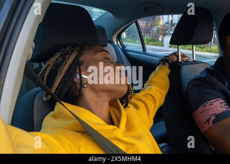 Woman sleeping in car on road trip Stock Photo