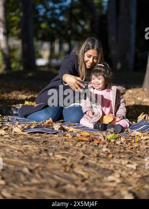 Mother and daughter with Down syndrome taking selfie in park Stock Photo