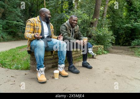 Two smiling men talking in park Stock Photo