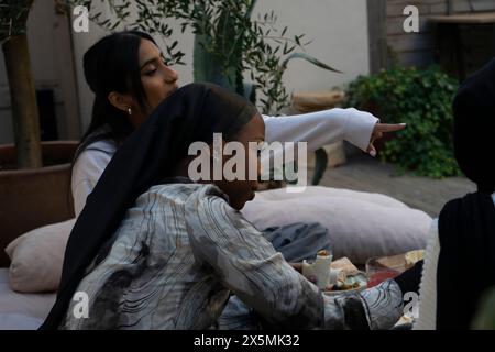 Friends wearing?hijabs?enjoying snacks on patio Stock Photo