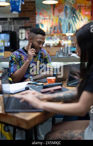 Creative professionals working together in cafeteria Stock Photo