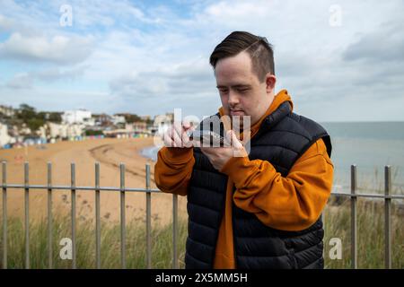 Man using smart phone by beach Stock Photo