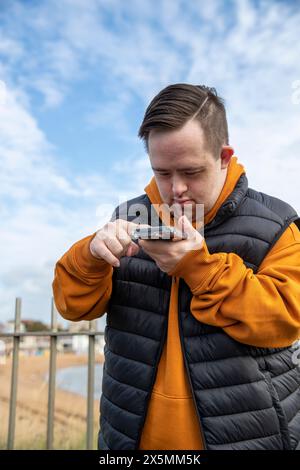 Man using smart phone by beach Stock Photo