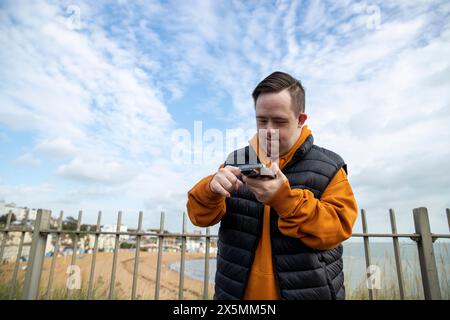 Man using smart phone by beach Stock Photo