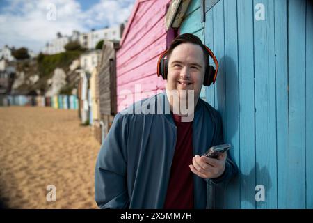 Portrait of man wearing headphones, holding smartphone Stock Photo