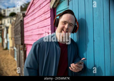 Portrait of man wearing headphones, holding smartphone Stock Photo