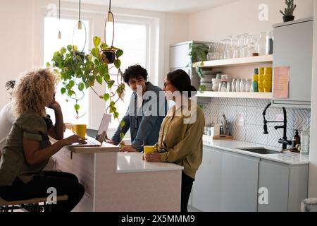 Creative professionals working on laptops in office kitchen Stock Photo