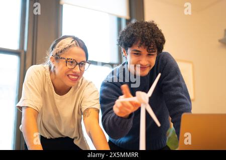 Engineers spinning wind turbine model in office Stock Photo
