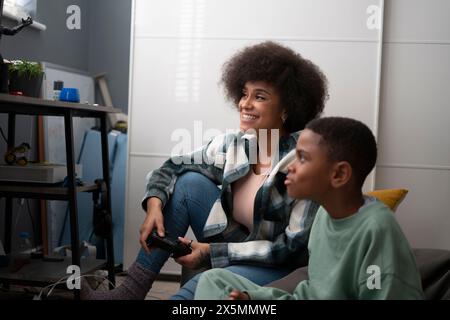 Mother and son playing video games at home Stock Photo