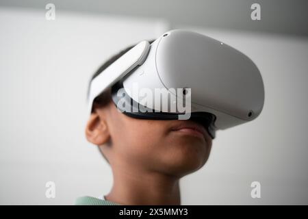 Boy using virtual reality headset at home Stock Photo