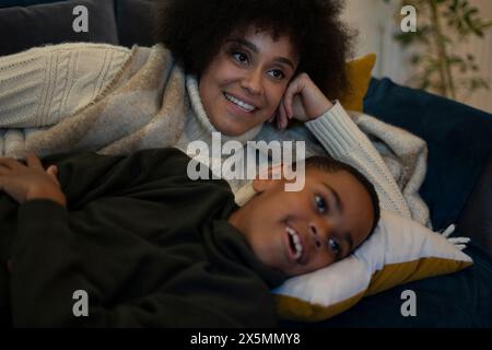 Mother and son lying on sofa Stock Photo